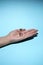 Man`s hand holds a glass transparent jar with pills on a light background close-up. medicines and vitamins. pharmaceuticals.