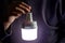 A man\'s hand holds a portable rechargeable LED emergency light