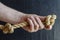 A man`s hand holds a rope with a knotted knot on a dark background