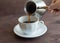 A man`s hand holds a Turk and pours freshly brewed coffee into a Cup