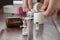 A man`s hand holds a white pill and a bottle of pills. In the foreground are bottles of powders for medicinal solutions