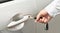 Man\'s hand inserting a key into the door lock of a car