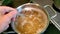 A man`s hand interferes with a spoon while cooking pasta.