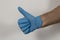 Man`s hand with latex glove with thumb up