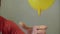 Man`s hand lets go of the yellow balloon from the hand, the ball deflates and flies away