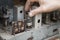 Man`s hand mounts the lamp to the old vintage tube radio.