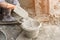 Man\'s hand plastering a wall with trowel.