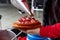 A man`s hand pouring oil over a portion of octopus, prepared in the traditional Pulpo a feira style. Galicia, Spain