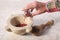 Man`s hand pouring some pink grains pepper in a marble mortar with copy space for your text
