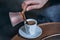 Man`s hand pours coffee into a cup