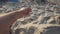 From a man`s hand pours sand on the beach.