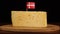 Man's hand put small in size toothpick with danish flag on cheese.