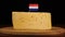 Man's hand put small in size toothpick with dutch flag on cheese.