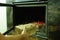 A man`s hand puts wood in the burning fireplace. Modern closed fireplace with glass