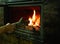 A man\\\'s hand puts wood in the burning fireplace. Modern closed fireplace with glass