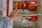 A man`s hand reaches for the food in the fridge upside down