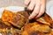 A man's hand reaches for a piece of fried carp fish at dinner. Delicious high calorie food