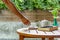 Man`s hand reaching for a coffee on wooden table.