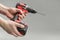 a man& x27;s hand removes the battery from a cordless tool. A man inserts a battery into a screwdriver. Repair and