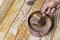 A man\\\'s hand removing a copper measuring scoop from a metal tin filled with dried lentils