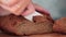 Man\'s hand is slicing homemade bread.