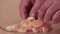 A man's hand slowly places the tangerine slices on the plate.