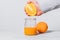 Man\'s hand squeeze orange juice into glass jar