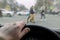 A man`s hand on the steering wheel of a car while braking at a pedestrian crossing