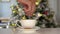 Man`s hand stirs christmas coffee, New Year tree on background