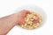 A man`s hand takes a white seed from a plate isolated on a white background.