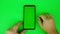 Man`s hand touch and scroll of mobile phone with vertical green screen and chroma key