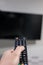 a man`s hand turning on a television that is anchored to the wall