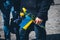 In the man\'s hand is a Ukrainian flag and flowers to honor the dead peaceful Ukrainians.