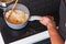 Man`s hands close-up stirring risotto in a pot with wooden spatula.