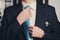 Man\'s hands closeup tying his tie knot