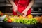 Man`s hands cutting fresh orange on kitchen