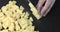 Man\'s hands cutting fresh potato on chopping board.