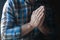 The man`s hands are folded in prayer. Christian believer`s prayer