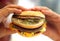 Man\'s hands, holding onto a burger