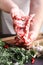 Man`s hands holding rack of the lamb in a process of cooking on a kitchen table