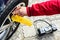 Man\'s hands inflating car wheel using automobile compressor with manometer.