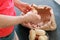 Man`s hands peeling potatoes. Paper bag with cleaning of the potatoes. Potatoes in bowl. Top view.