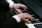 Man`s hands playing on a piano at the concert