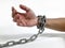 a man\'s hands shackled by chains