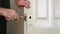 Man`s hands use file to expand hole for door lock