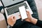 Man`s hands using laptop with blank screen on desk in home interior. Mockup image white screen