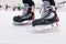Man\'s hockey skates on ice background