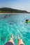 man\'s legs closeup on boat and happy friends diving from sailing