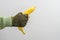 A man`s military hand holds a banana on a gray background
