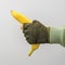 A man`s military hand holds a banana on a gray background